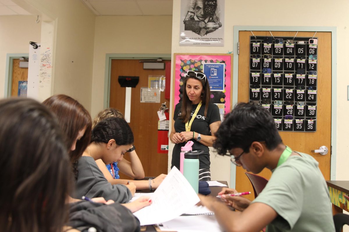 Mrs. Waugh watches her students as they work on graphing data from the lab that took place during class. Prior to becoming a teacher, Waugh worked as a fire protection engineer. ”I thought it would be most impactful if I could teach science here [at Dreyfoos].” Mrs. Waugh said. “And I had loved my physics teacher. He was part of why I became an engineer,” 