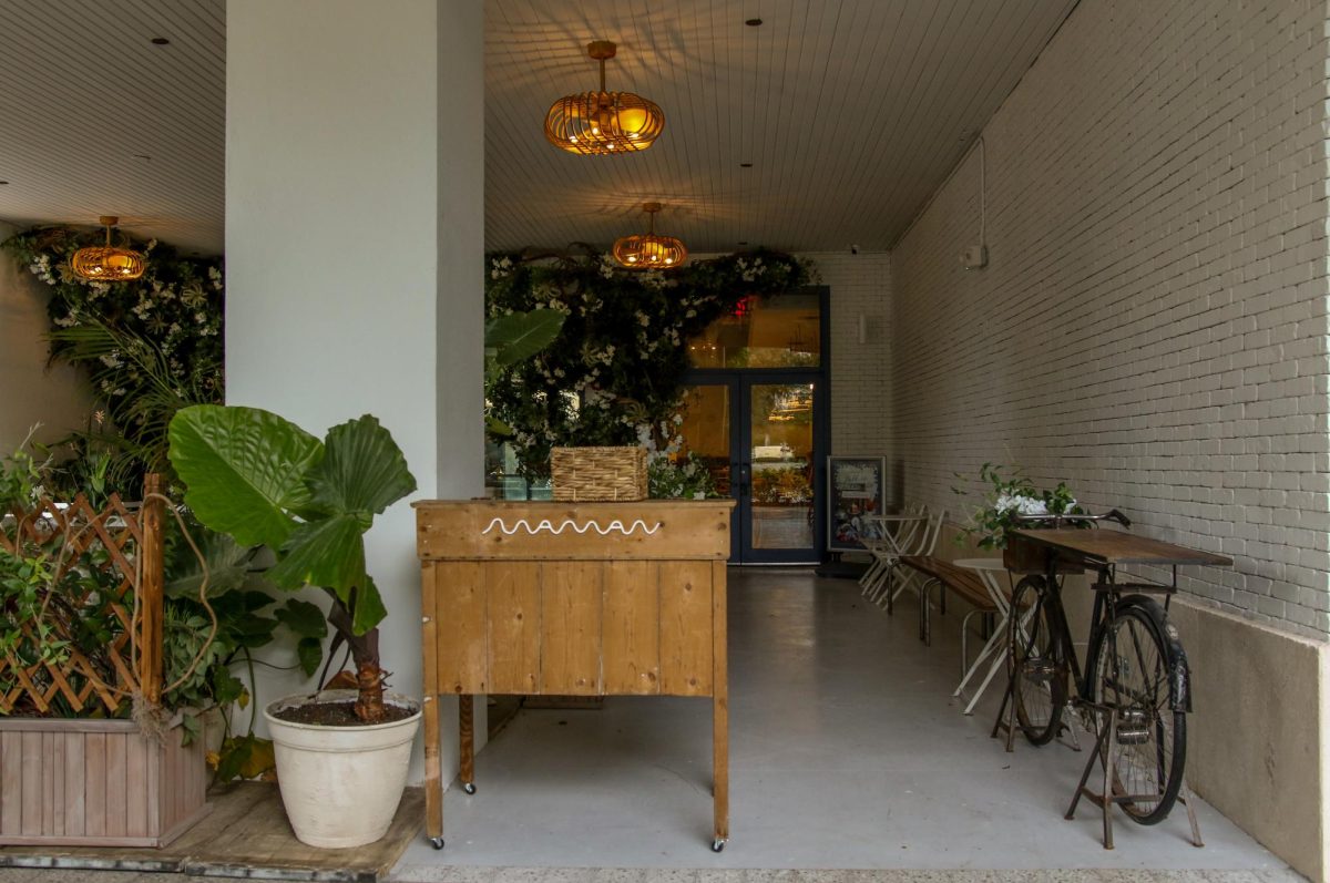 Nestled behind trees, the storefront of Maman in the Square, located at 473 S Rosemary Ave. 
