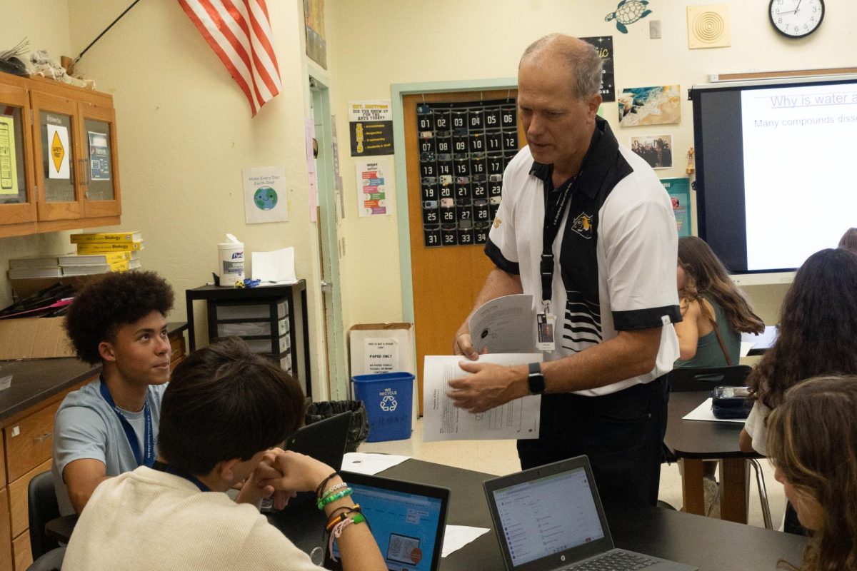 Conversing with a group of students, new biology teacher Richard Zullo instructs them on how to complete an assignment about the properties of water. 
