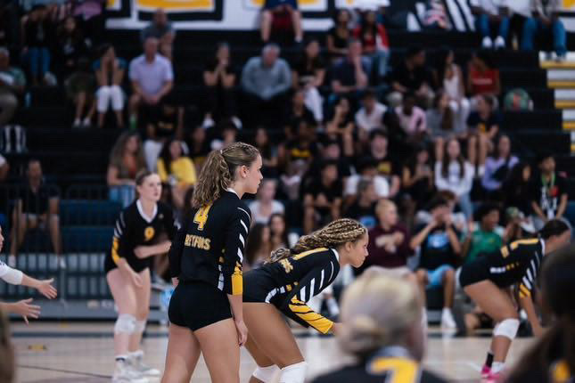 Anticipating the ball, visual junior Tora Cooper stands on the court in front of a crowd of students and parents. “My favorite part of being on the team is having a community that is always supportive of one another,” Cooper said.
(Photo courtesy of Lotta Cooper)