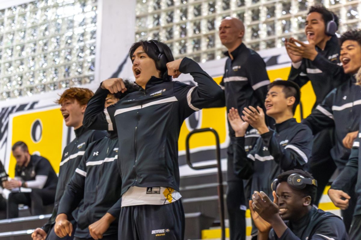 Strings senior William Tong and other boys basketball team members cheer on the girls basketball team after a three-point shot was made during the second quarter. The boys team played their first home game against SLAM! Palm Beach (Sports Leadership and Management) following the girls game.