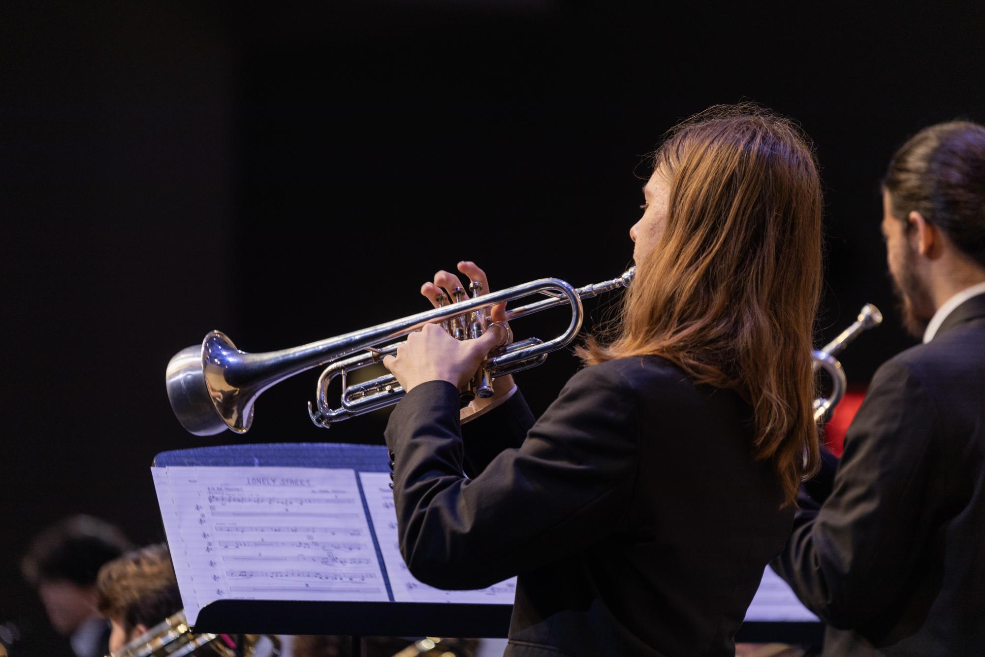 Staged in the back of the ensemble, trumpet players utilized a variety of trumpet mutes to amplify and augment their pitch and musical tone throughout different songs in the concert.