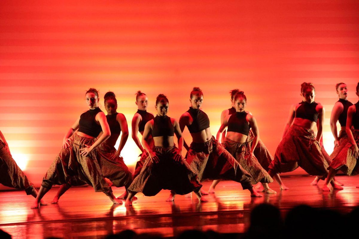 Surrounded by her peers, dance senior Emma Elder performs a modern repertory piece called “The Opposition” at the annual fall dance concert on Nov. 15. The piece was choreographed by dance teacher Ricardo Pena. Elder described the piece as one with “high energy” accompanied by bold-colored lighting.

(Caption by Mia Salvador)