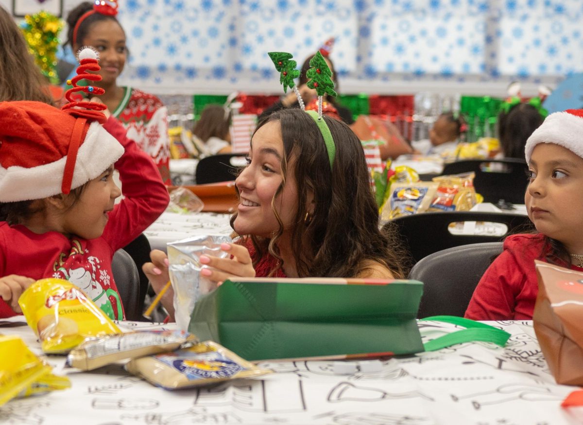 ARTS Club member and theatre junior Ashley Diaz-Proenza interacts with children during snack time at the Jefferson Jubilee, an annual event hosted by ARTS Club to bring holiday cheer to students.
