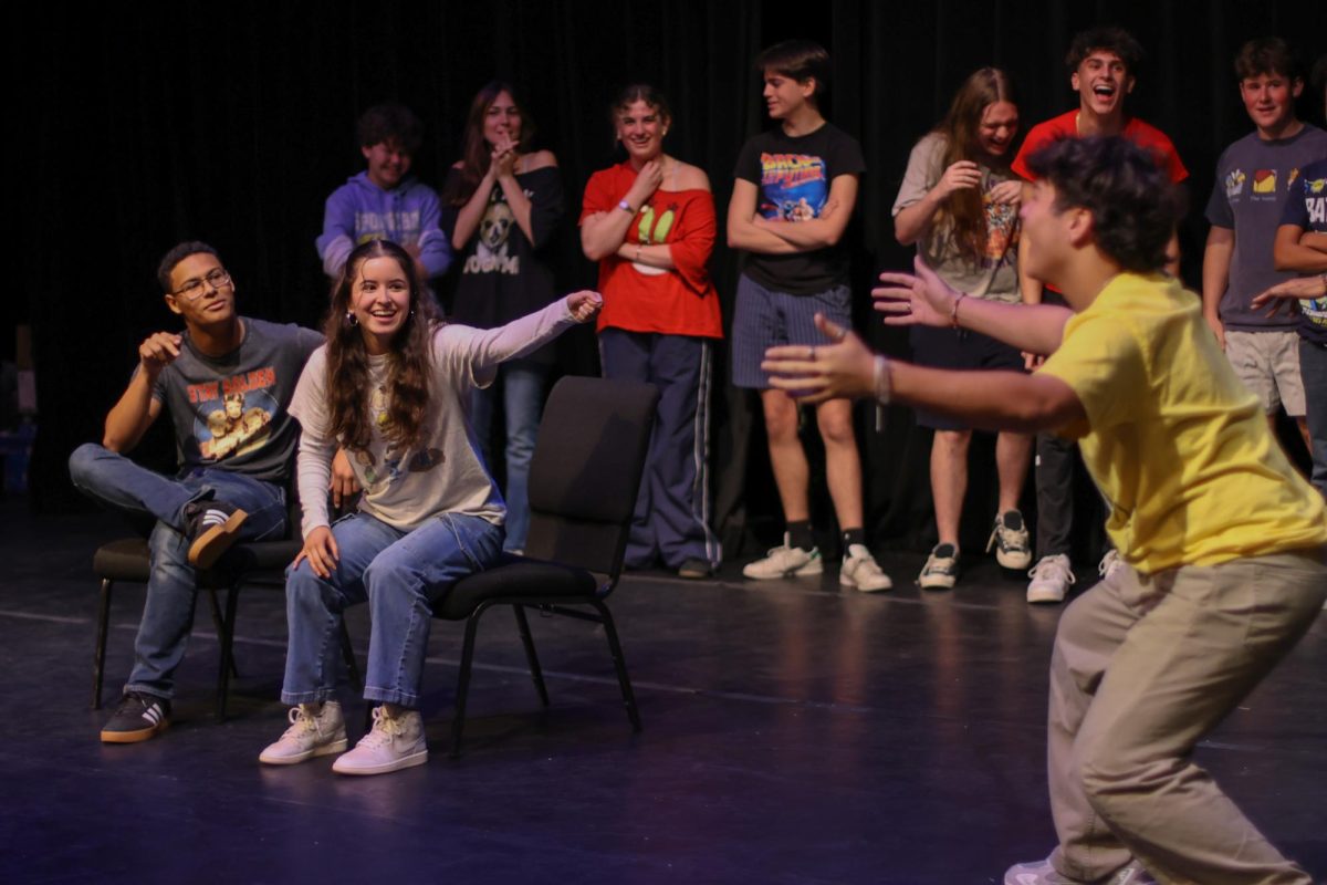 Theatre juniors Darien Batista and Andrea Mora "hit pause" on an improvisation scene in the Jan. 17 Hairy Details show, causing theatre sophomore Richard Moore to stop his performance while the two discuss the scene in character. Acting as a movie producer and a talk show host during their improvisation game, Batista and Mora narrate scenes of a "movie" while accompanying performers, such as Moore, who portray what Batista and Mora describe. “Sometimes when the shows don’t land on a specific holiday, we don’t have a theme,” Mora said. “But this show, our presidents decided to have the theme as movies and T.V. shows, hence our t-shirts.” 