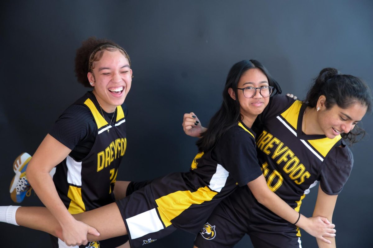 Power forward and communications senior Shailee Patel, girls basketball captain and theatre senior Guilabreah Pacheco, and Small forward and band senior Kayla Burgess, girls basketball captain and theatre senior Guilbrhea Pacheco, and power forward and communications senior Shailee Patel (pictured left to right) attempt to pose for a “JCPenney” photo, which is typically a family portrait with seemingly awkward poses. Although they do not always see one another during school hours, the team comes together when on the court.