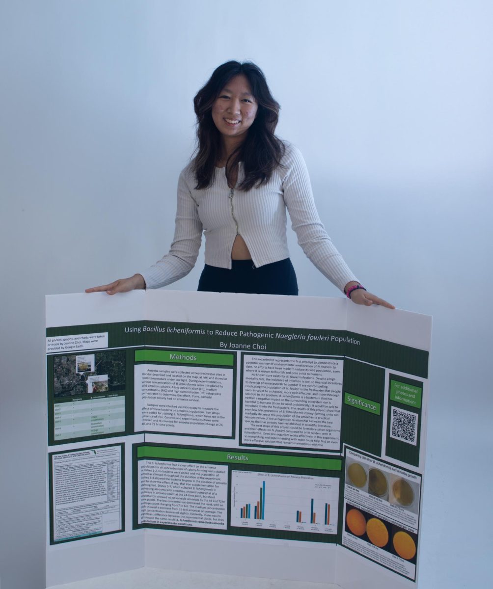 Piano freshman Joanne Choi poses with her trifold science fair board for ISEF. Choi did a study on different types of amoeba and cell populations in her project. “I was just reading through a few articles, and I noticed that a consistency among the articles was that (they) mentioned an issue that they couldn't culture it (the algae) at all,” Choi said. “So it was just a very difficult algae to study because you can't culture it and because it's so fragile, it doesn't live very long.”