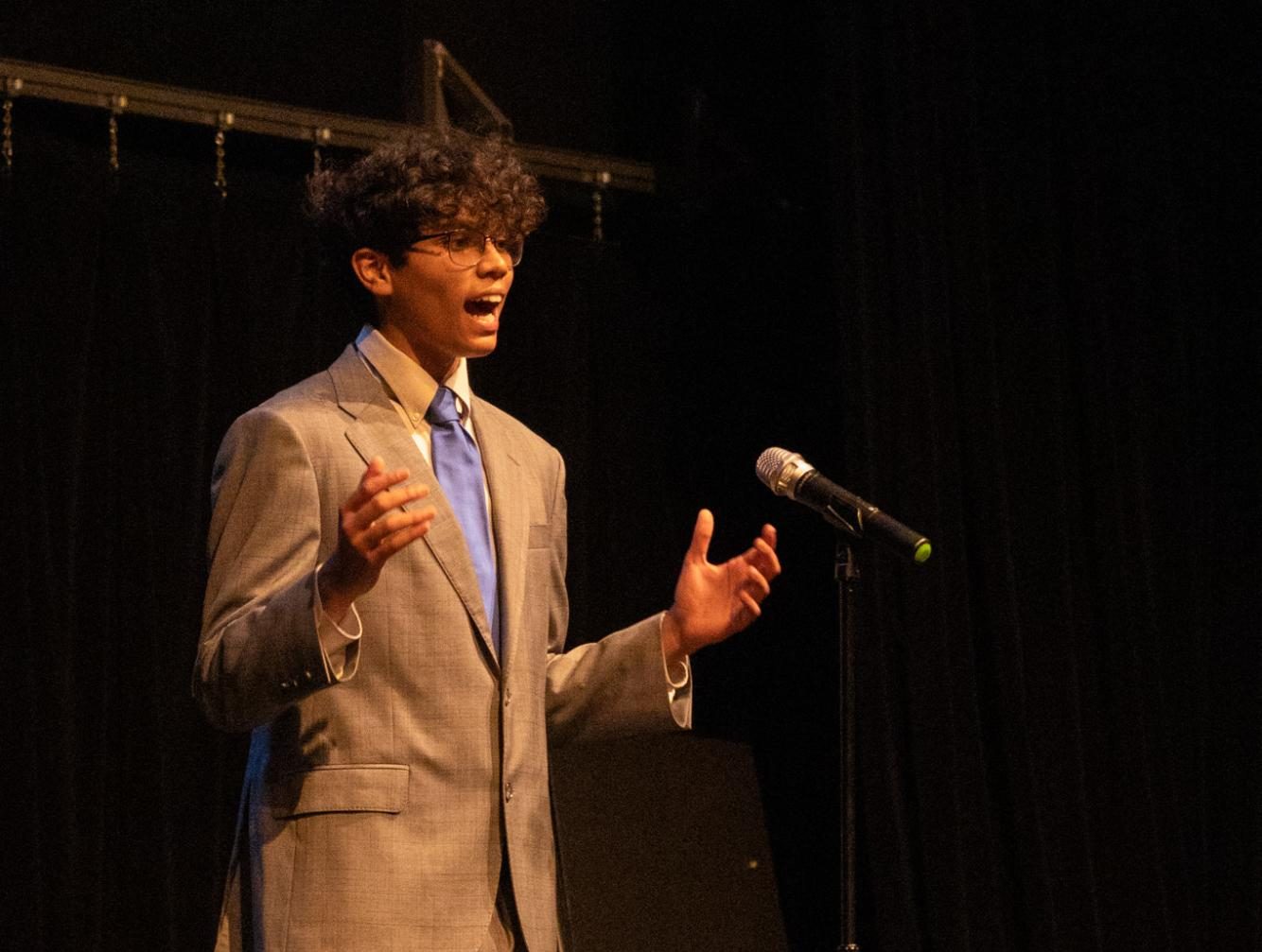 Gesturing while telling his speech, communications freshman Zahab Ali performs his speech “Checkmate."
