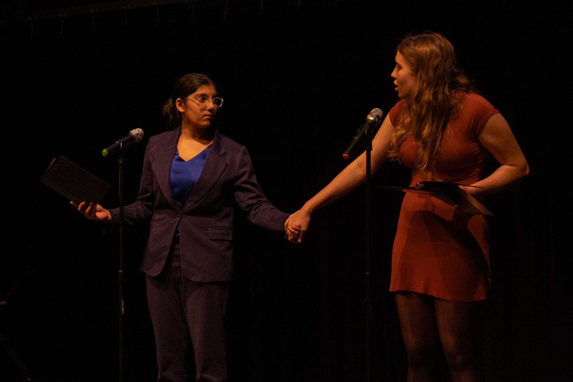 Holding hands, communications sophomores Trisha Babji Rao and Maya Bourak perform their slam poem, “Books Behind Bars.” “This poem explored book bans happening currently in the states of Florida and how it impacts future generations," Bourak said. 