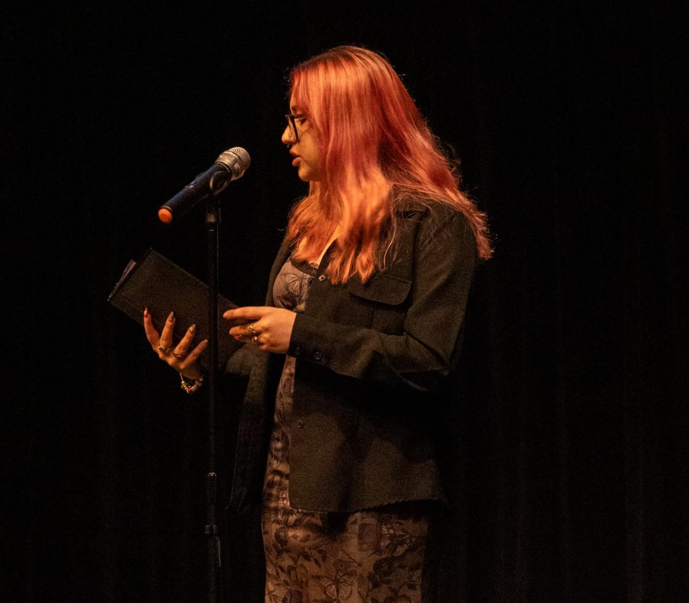 Black binder in hand, communications junior Gabriella Escobar performs one of her segments in the group slam poem, "How to Build An Alpha Male."