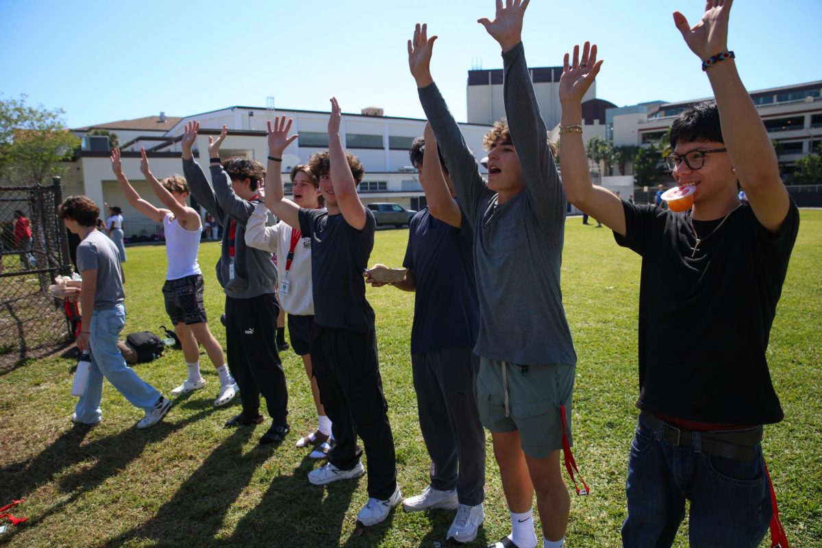 While participating in a lunch practice for Powderpuff, juniors put their hands up as a part of their choreographed dance.
