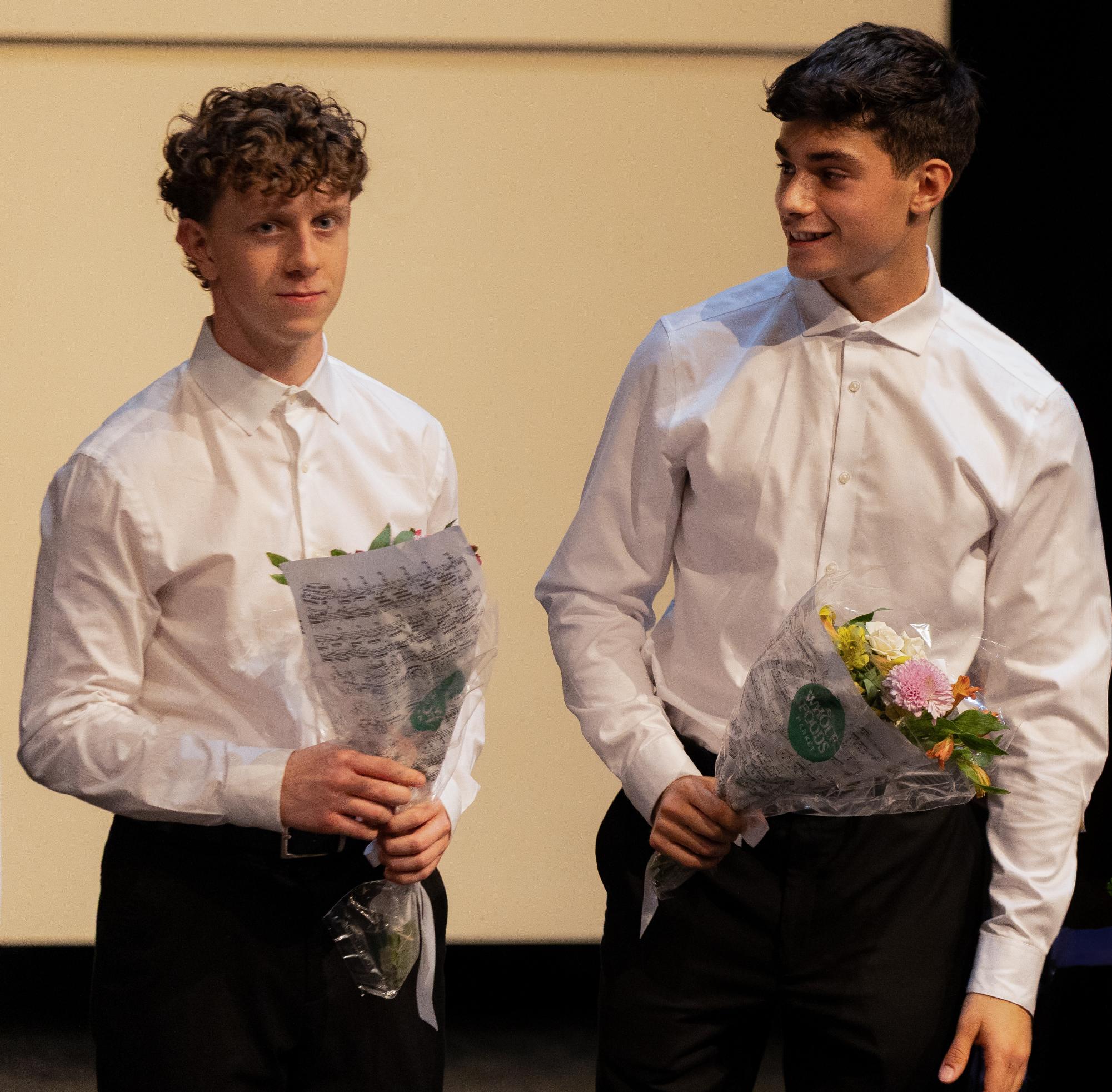 Standing before taking their final bow, piano seniors Jeffrey Zimmerman and Noah Kriegstein hold flowers in their hands as they end the recital. “I just picked composers that I really enjoyed playing,” Jeffrey Zimmerman said. “Then, I sat down with my private teacher and picked (the) repertoire that we liked. Practicing it was definitely stressful leading up to the recital, but we did some practice recitals for the class.”