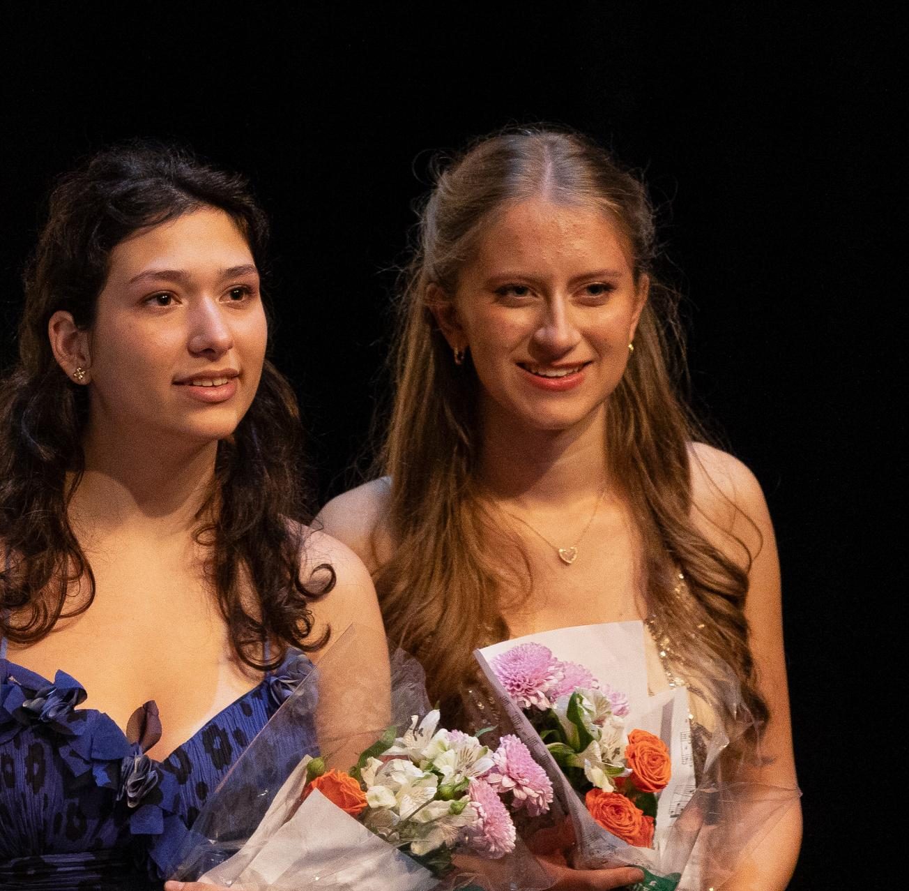 Smiling at the audience, piano seniors Ana Tejada and Hannah Zimmerman hold flowers while lining up for a bow. “I definitely feel like I was very prepared for playing in front of other people,” Hannah Zimmerman said. “On top of already having played for people in the past, Mrs. Katz gives us those group sessions too (for practice).”